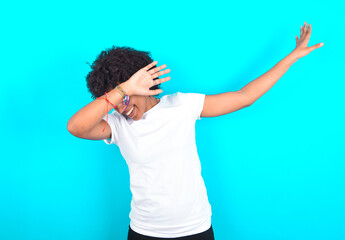Photo of funky young woman with afro hairstyle wearing white T-shirt against blue wall show disco...