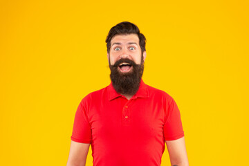 amazed guy with beard and hairstyle on yellow background, face