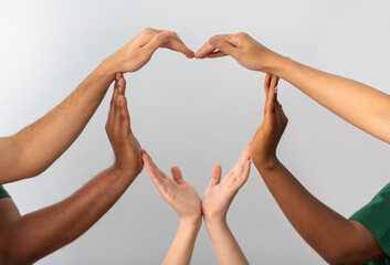charity, love and valentine's day concept - close up of hands making heart gesture over grey...