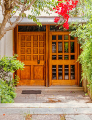 A contemporary house entrance with natural wood and glass door.