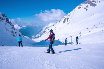 Fototapeta na wymiar Snowboarders and skiers standing on snowy mountain slope at winter resort