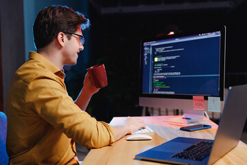 Side profile view young freelancer software engineer IT specialist programmer man in shirt work at...