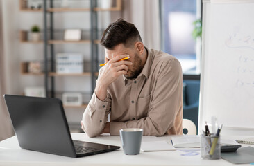 distance education, remote job and stress concept - tired male teacher with laptop computer working at home office