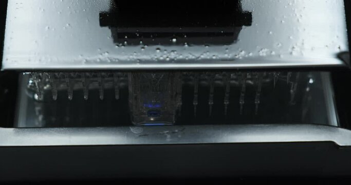Extreme Close up of Resin MSLA 3D Printer moving up and down during printing object using uv light.