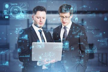 Attractive european businessmen using laptop with abstract creative business charts and binary code on blurry office interior background. System engineering and digital transformation concept. 