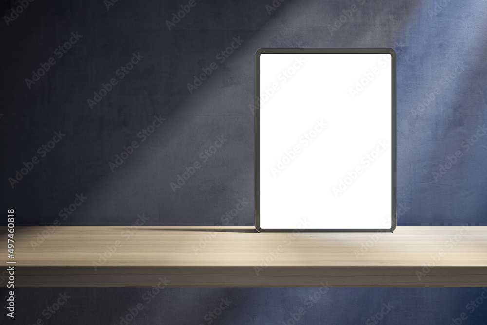 Poster close up of blank white tablet on wooden desktop and concrete wall background with shadows and mock 