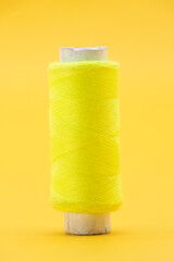 single yellow color yarn or spool thread over on yellow background