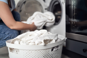 Fototapeta na wymiar Close up of caucasian woman making laundry at home