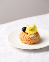 Modern sweet puffs - French choux pastry (eclairs) with lemon cream and blueberries