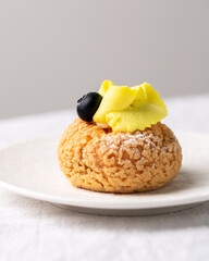 Modern sweet puffs - French choux pastry (eclairs) with lemon cream and blueberries