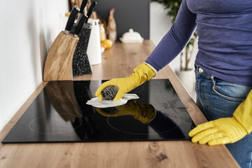 Close up of caucasian woman cleaning ceramic glass cooktop
