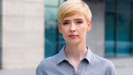 Close-up female serious face portrait outdoors caucasian middle aged business woman boss blonde...
