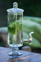 juicer with water flavored with mint, mint flavored water, glass jug with tap