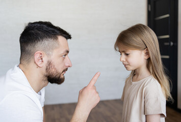 Domestic Violence. Man threatening his daughter with his fist. Domestic problem in family. Dad...