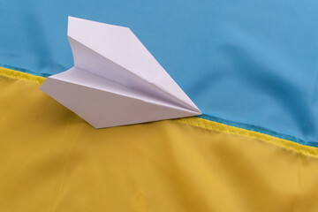 paper airplane on the background of the flag of Ukraine