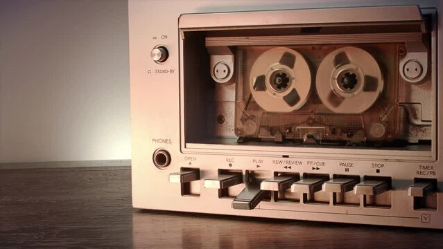 Close up shot of a vintage cassette player rolling in a seamless video loop. A vintage music background with copy space to use your own text