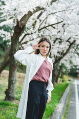 桜の花を見ながら散策する女性