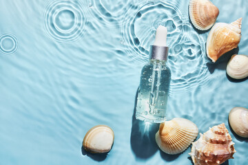 Organic cosmetic with with sea minerals. Skincare cosmetic product and shells on blue water...