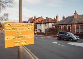 Street with Protest Sign: Leafy suburb, with a protest sign hanging around a lampost.