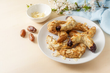 Homemade cookies from almond, dates, oat flakes and dark chocolate without sugar, spring flower branch and blue napkin on a wooden table, copy space, selected focus