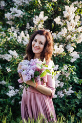 beautiful woman with a bouquet of lilac flowers in spring