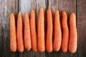 large orange carrot fruits on a wooden background