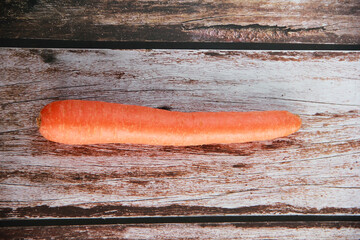 large orange carrot fruits on a wooden background