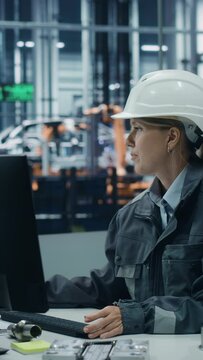 Vertical Screen. Car Factory: Female Technician Working on Computer. Monitoring, Equipment Production. Automated Robot Arm Assembly Line Manufacturing Electric Vehicles