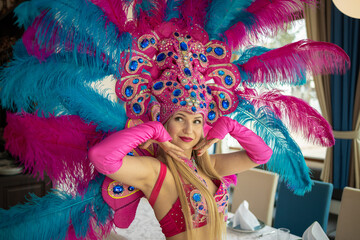 Danseres in een carnavalskostuum met grote gekleurde veren op vakantie