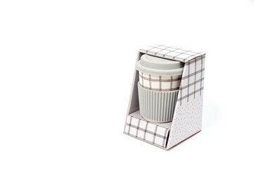 Checkered ceramic cup with rubber lid, shot against a white background.