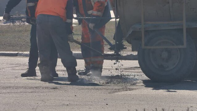 Maintenance Service Workers Repair Pothole with Bitumen Asphalt on Bad Road