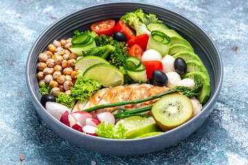 Buddha bowl dish with chicken fillet, avocado, asparagus, chickpeas, broccoli, radish, chicken, cucumber, tomatoes, olives, mozzarella. Detox and healthy superfoods concept, top view