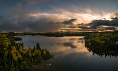Rain clouds start to clear to reveal a colorful landscape after a stormy autumn day at Forest Lake,...
