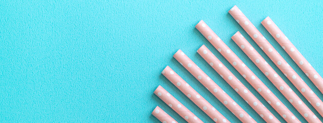 Biodegradable paper straw set on blue table background.