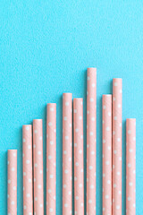 Biodegradable paper straw set on blue table background.