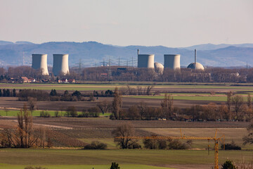 Silhouette of a nuclear power plant with houses and vineyards in the foreground