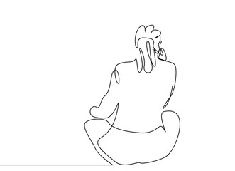 A beautiful woman sitting on the floor with her back turned thoughtfully