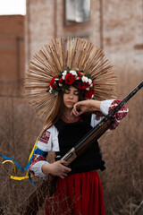 Ukrainian woman in a traditional national costume with a weapon in her hands defending her country...