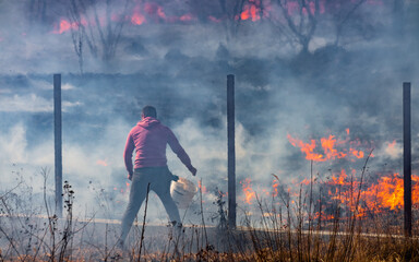 The man extinguishes the fire alone. Seasonal ecological catastrophe of burning