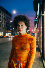 Fototapeta premium Young black woman curly hair stylish fashionable posing outdoor looking camera cool attitude