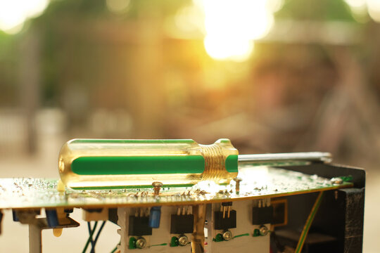 Close-up of electronics technician. Electronic technology troubleshooting circuit board and repair on sunlight background