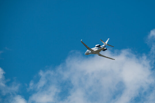 Private Jet Flying Overhead In The Deep Blue Sky