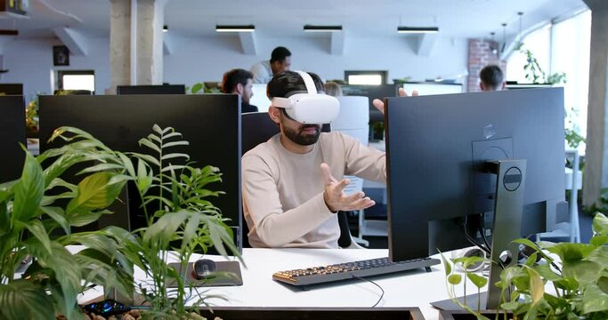 Arabian man in VR glasses moving hands in air. Male in headset having virtual reality experience. Moving hands in air. Futuristic. Augmented. IT team. Call center of future. Coworking space.