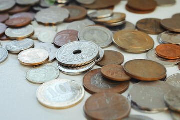 scattered coins from different countries lie on the surface of the table, selective focus, macro
