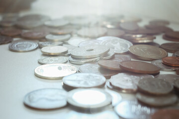 scattered coins from different countries lie on the surface of the table, selective focus, macro