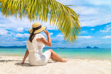 Woman under palm leaf
