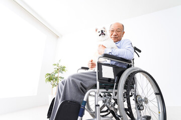 犬を飼う車椅子に乗った高齢の男性