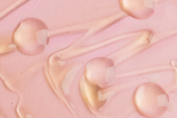 Liquid gel texture closeup on pink background. Cosmetic product texture
