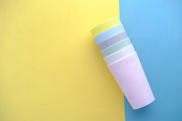 Disposable plastic glass on color background 