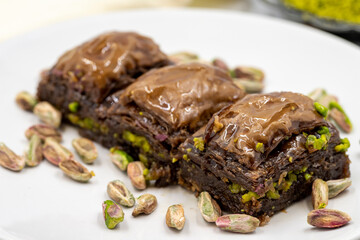 Chocolate baklava with pistachio on a white background. Traditional Mediterranean cuisine delicacies. Close-up Chocolate Baklava. local name cikolatali baklava